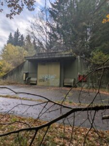 Abandoned military bunker surrounded by forest, ideal for urban exploration with a lost place map.
