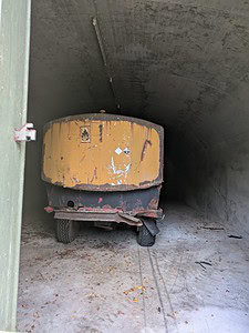 Rusty trailer in an abandoned concrete tunnel, perfect for urban exploration and lost places map enthusiasts.