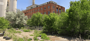 Abandoned brick building surrounded by trees, ideal for urban exploration. Discover more on our lost place map.