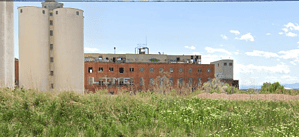 Abandoned factory with graffiti in a field, perfect for urban exploration. Discover more on our lost place map.