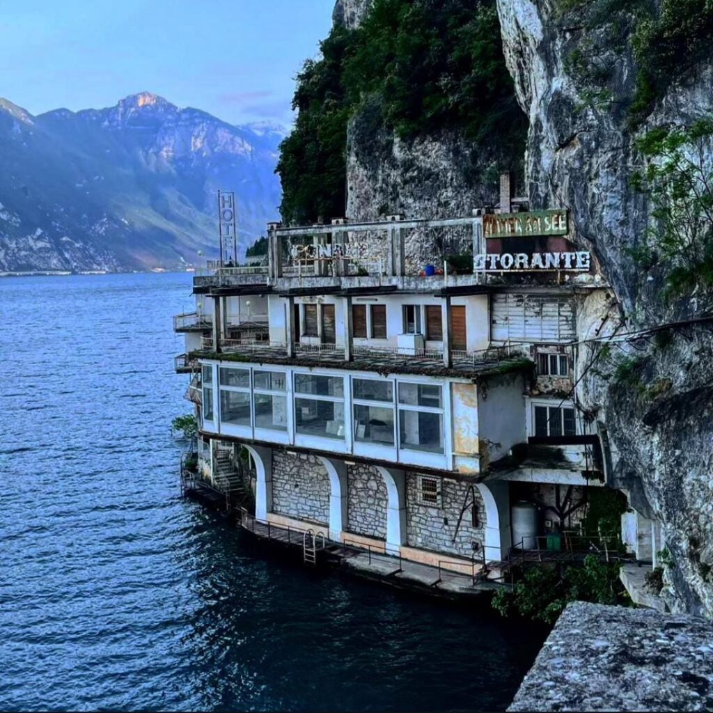 Abandoned cliffside hotel with water view, ideal for urbex exploration and photography.