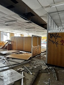 Abandoned office space with graffiti, ideal for urban exploration. Urbex enthusiasts can map this unique forgotten place.