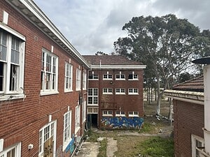 Abandoned red brick building with graffiti, featured on a lost place map for urban exploration enthusiasts.