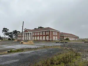 Abandoned brick building on a gloomy day, perfect for urban exploration and lost place map enthusiasts.