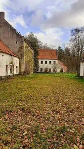 Abandoned buildings with mossy walls in a rural area, perfect for urban exploration and featuring on a lost place map.