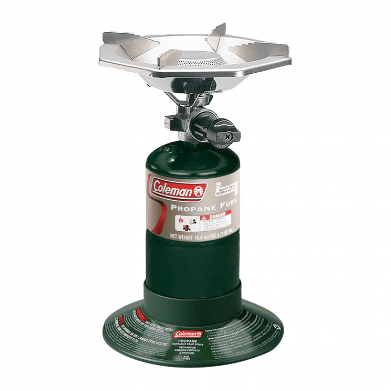 Portable Coleman camping stove with burner on green propane canister for outdoor cooking.
